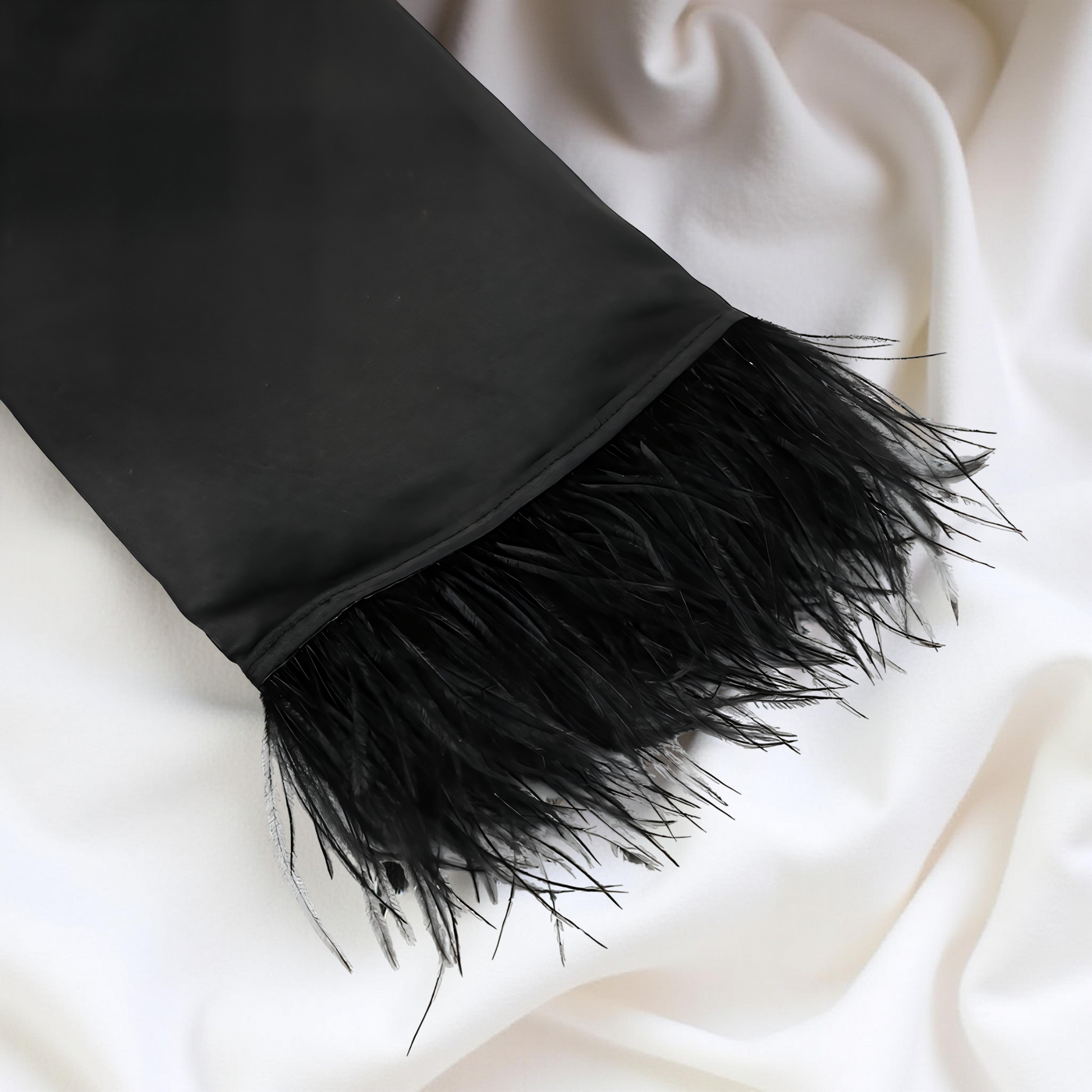 Black feathered scarf on a white fabric background Velourine attire